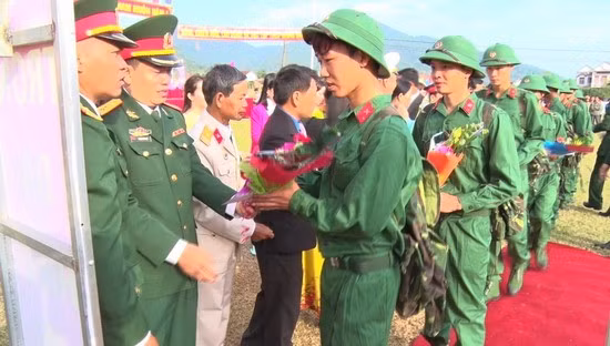 Lãnh đạo huyện Vĩnh Thạnh tặng hoa chúc mừng tân binh trước lúc lên đường. Ảnh: X.DŨNG