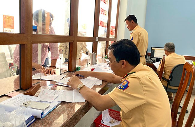 Cán bộ, chiến sĩ Đội Sát hạch, cấp GPLX cơ giới đường bộ (Phòng CSGT, CA tỉnh) đang tiếp nhận, giải quyết hồ sơ đổi, cấp GPLX cho người dân. Ảnh: N.C
