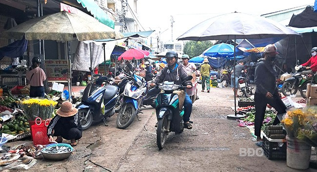 Tiểu thương lấn chiếm lòng đường Huỳnh Văn Thống để mua bán khiến việc đi lại khó khăn. Ảnh: V.L Tiểu thương lấn chiếm lòng đường Huỳnh Văn Thống để mua bán khiến việc đi lại khó khăn. Ảnh: V.L