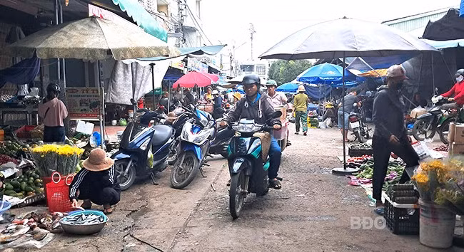 Tiểu thương lấn chiếm lòng đường Huỳnh Văn Thống để mua bán khiến việc đi lại khó khăn. Ảnh: V.L