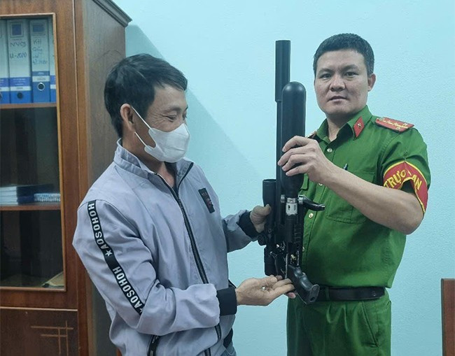 CA phường Thị Nại vận động một người dân giao nộp súng. Ảnh: T.LONG