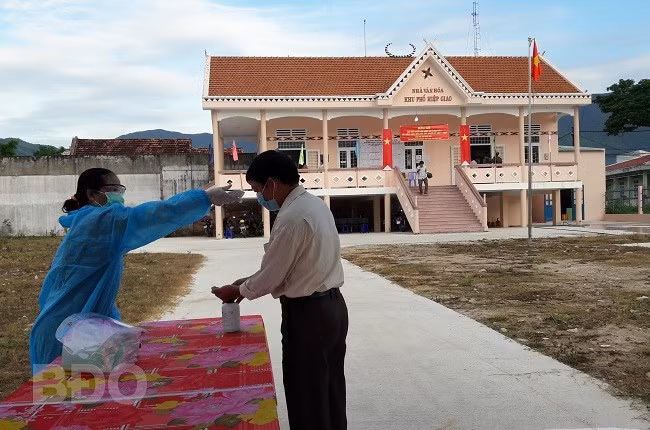 Cử tri được đo thân nhiệt trước khi vào khu vực bỏ phiếu. ẢNH: HẠNH PHÚC