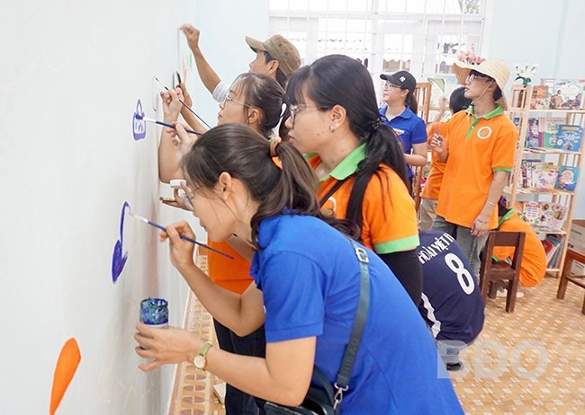 Vẽ tranh tường, trang trí góc thư viện là một trong những hoạt động cố định được các tình nguyện viên chăm chút. - Trong ảnh: Các tình nguyện viên trang trí điểm đọc tại Trường Tiểu học An Toàn (xã An Toàn, huyện An Lão). Ảnh: D.L