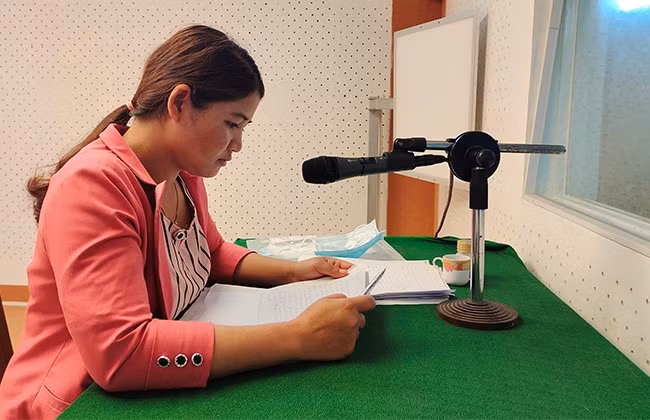 Chị Đinh Thị Liêng đọc chương trình phát thanh tiếng H’re. Ảnh: D.T.D