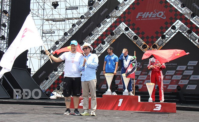 Ông Trần Việt Anh, Chủ tịch HĐQT Công ty CP Bình Định F1, trao cờ luân lưu đăng cai chặng tiếp theo cho đại diện nước Ý. Ảnh: TRỌNG LỢI