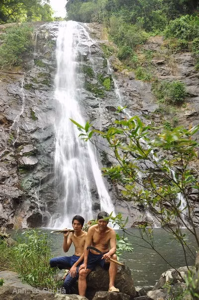 Du khách chụp ảnh lưu niệm bên thác nước.