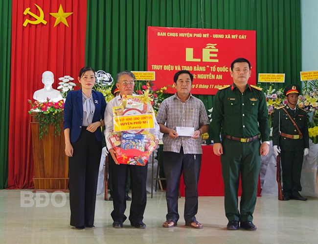 Bộ CHQS tỉnh và lãnh đạo UBND huyện Phù Mỹ tặng quà cho thân nhân gia đình Liệt sĩ. Ảnh: Thành Phúc