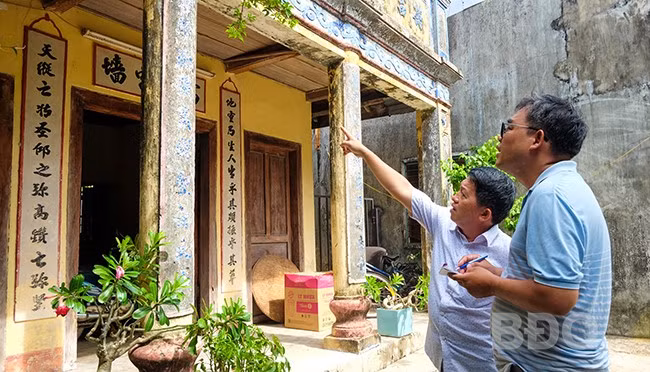 TS Võ Minh Hải (bìa phải) ghi lại nội dung các câu đối Hán Nôm tại Văn thánh miếu Phù Cát. Ảnh: NGỌC NHUẬN