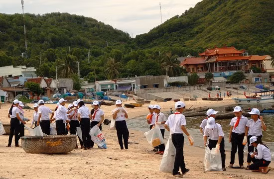 Các em học sinh tham gia hoạt động làm sạch bãi biển Nhơn Hải do MCD phối hợp tổ chức.