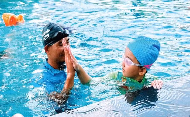 Cô học trò nhỏ Lương Ngọc Khánh Ngân (SN 2017, ở phường Đống Đa, TP Quy Nhơn) vui vẻ đập tay với thầy Hồ Ngọc Cường sau khi hoàn thành bài kiểm tra về cách đứng nước.