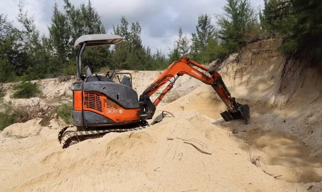 Xe múc chờ sẵn trong hố cát khu vực phía sau SVĐ xã Mỹ Thành chờ xe tải đến để hoạt động. Ảnh: V.L