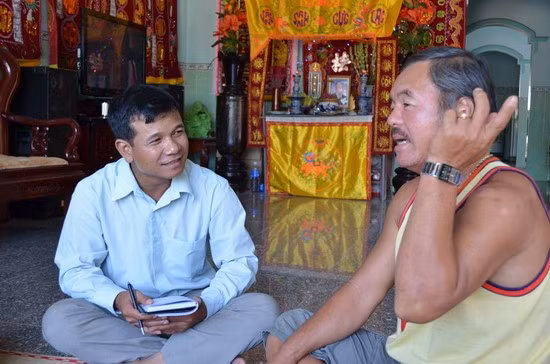 Thuyền trưởng Nguyễn Văn Trọng (bên phải) kể chuyện đánh bắt hải sản ở ngư trường Hoàng Sa, Trường Sa với phóng viên Báo Bình Định. Ảnh: CÔNG CƯỜNG
