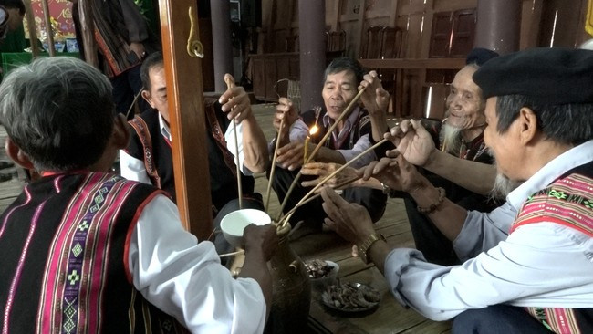 Người Bana mời rượu khách ngày Tết. Ảnh: XUÂN DŨNG