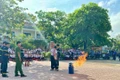 Học sinh được hướng dẫn cách sử dụng bình chữa cháy xách tay. Ảnh: N.L
