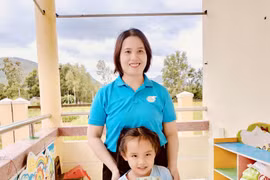 Bé Hồ Ngọc Nhơn vui mừng khi được mẹ đỡ đầu đến thăm và trao quà. 