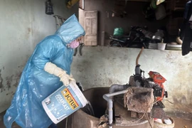 Cán bộ y tế khử khuẩn giếng nước bằng Cloramin B. 