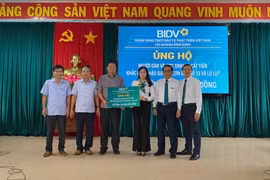 Đại diện BIDV trao biểu trưng hỗ trợ cho đại diện lãnh đạo xã Cát Tiến. Ảnh: Nguyễn Dũng
