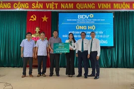Đại diện BIDV trao biểu trưng hỗ trợ cho đại diện lãnh đạo xã Cát Tiến. Ảnh: Nguyễn Dũng