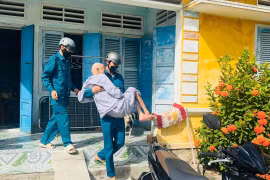 Xã Tuy Phước Đông hỗ trợ người cao tuổi đi lại khó khăn đến nơi tránh trú. Ảnh: ĐVCC