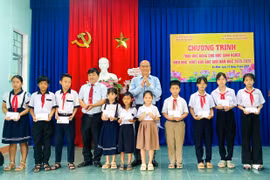 Ban tổ chức trao học bổng khuyến học cho học sinh có hoàn cảnh khó khăn. Ảnh: T.K