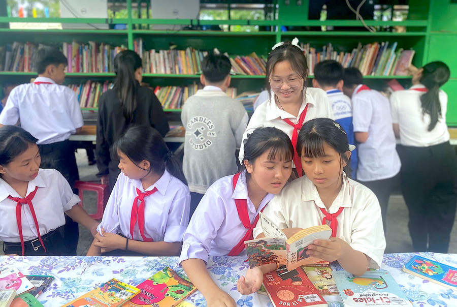 Các học sinh đọc sách tự chọn tại các kệ sách và từ xe Thư viện lưu động. Ảnh: T.N img-2950.jpg