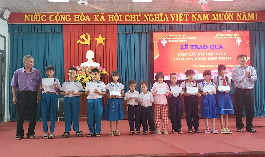 Các em học sinh phấn khởi đón nhận quà. Ảnh: X.V 1a.jpg