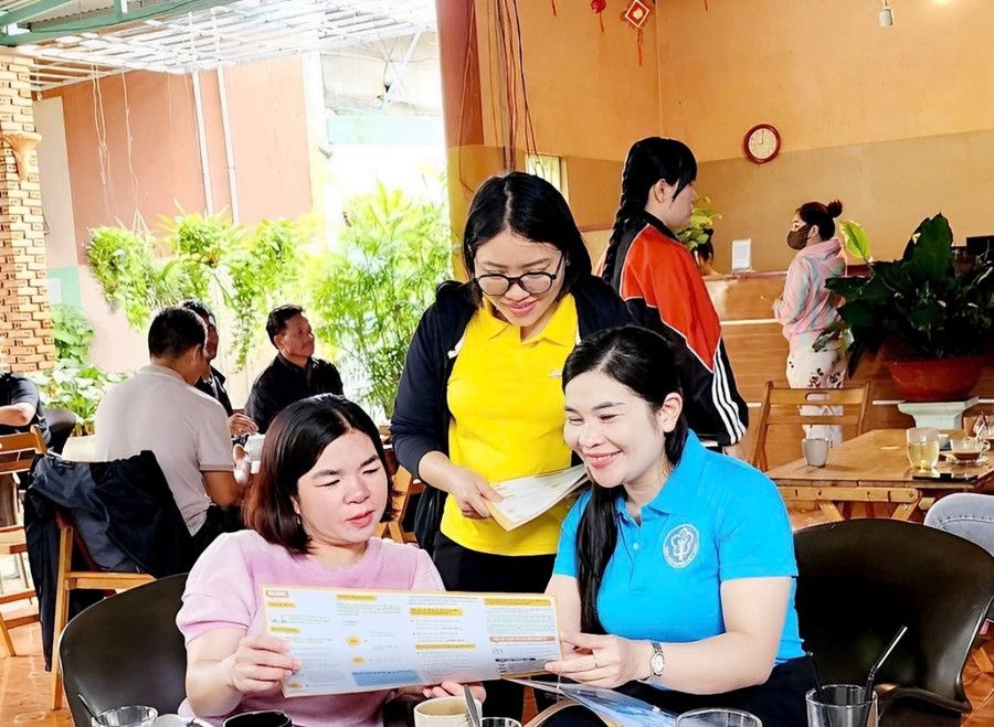 Cán bộ BHXH và nhân viên Bưu điện vận động, tuyên truyền về BHXH, bảo hiểm y tế. Ảnh: ĐVCC 2.jpg