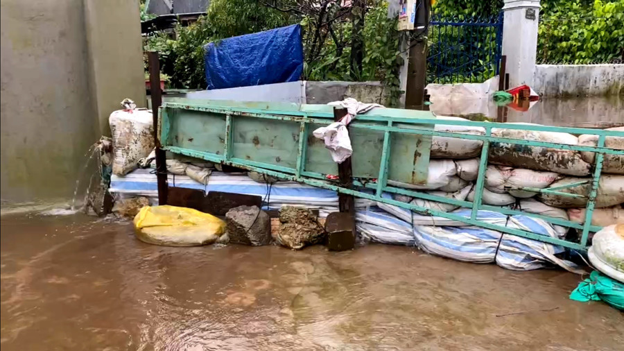 Người dân dùng bao cát, ván, khung sắt để chắn nước, hạn chế thiệt hại về tài sản. Ảnh: B.B anh-2-3573.jpg
