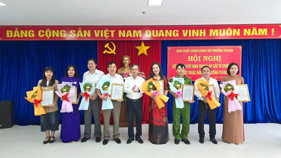 Bí thư Đảng ủy phường Pleiku Nguyễn Xuân Phước (giữa) trao quyết định và tặng hoa chúc mừng các tổ chức Đảng mới thành lập. Ảnh: B.B anh-2-1-17.jpg