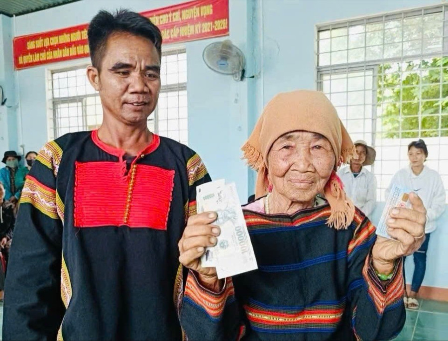 Bà Nay H’Prươr phấn khởi nhận tiền hỗ trợ của Chính phủ. Ảnh: Lạc Hà rcom-tuyet.jpg