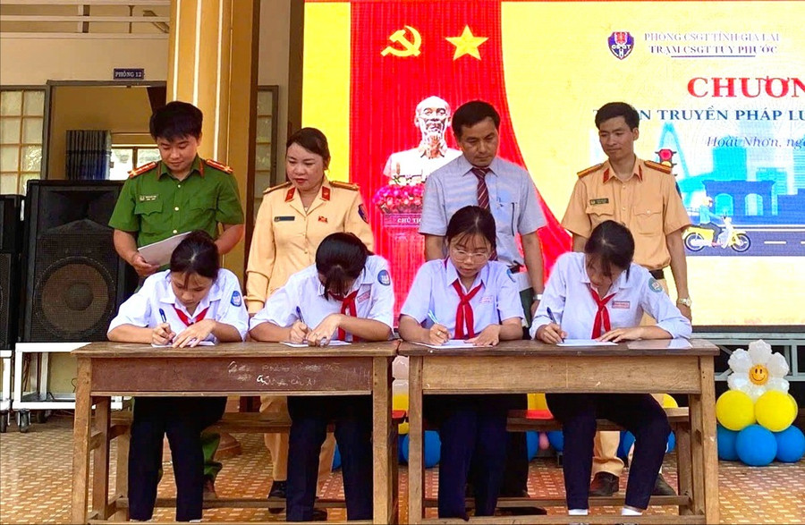 Học sinh Trường THCS Hoài Thanh Tây ký cam kết tham gia giao thông an toàn. Ảnh: N.L img-0157.jpg
