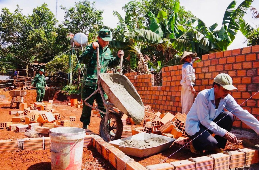 Cán bộ, chiến sĩ Đồn Biên phòng Ia Pnôn hỗ trợ người dân xóa nhà tạm, nhà dột nát. Ảnh: P.D 1nhatam.jpg