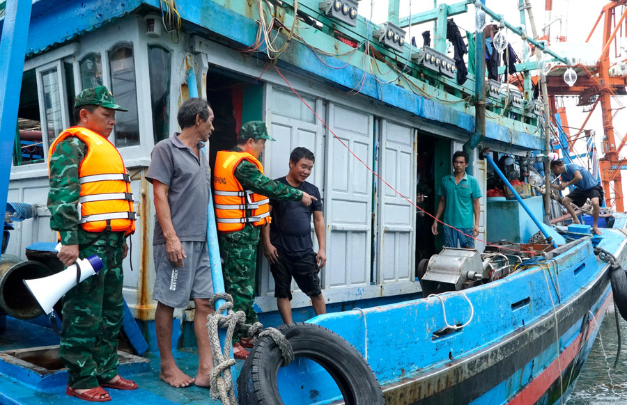 Cán bộ, chiến sĩ Đồn Biên phòng Cửa khẩu cảng Quy Nhơn tuyên truyền để các chủ tàu thuyền tránh bão. Ảnh: Công Cường can-bo-chien-si-don-bien-phong-cua-khau-cang-quy-nhon-van-dong-tuyen-truyen-cac-chu-tau-thuyen-tranh-bao.jpg