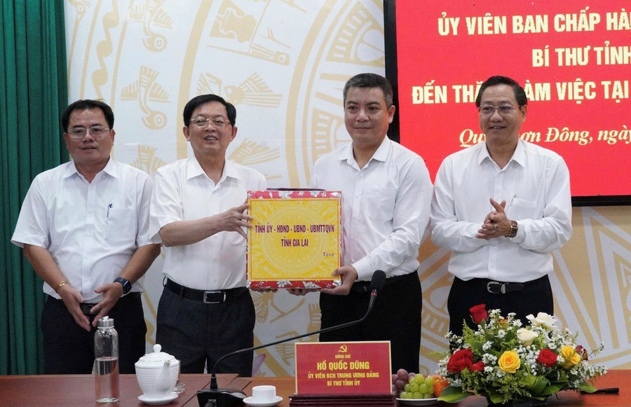 Bí thư Tỉnh ủy Hồ Quốc Dũng (thứ 2 từ trái sang) tặng quà cho lãnh đạo phường Quy Nhơn Đông. Ảnh: Nguyễn Hân 3.jpg