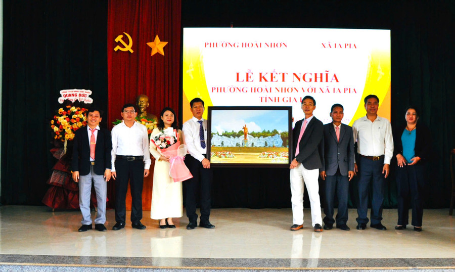 តំណាងរាស្ត្រមកពីឃុំអៀពៀ (ខាងស្តាំ) ប្រគល់រូបថតទីលានឯកភាពធំជូនដល់សង្កាត់ហយញ៉ុង។ រូបថត៖ P.D. z7321922009184-53059bc8787cbf9d8a8c98332b7c9c82.jpg