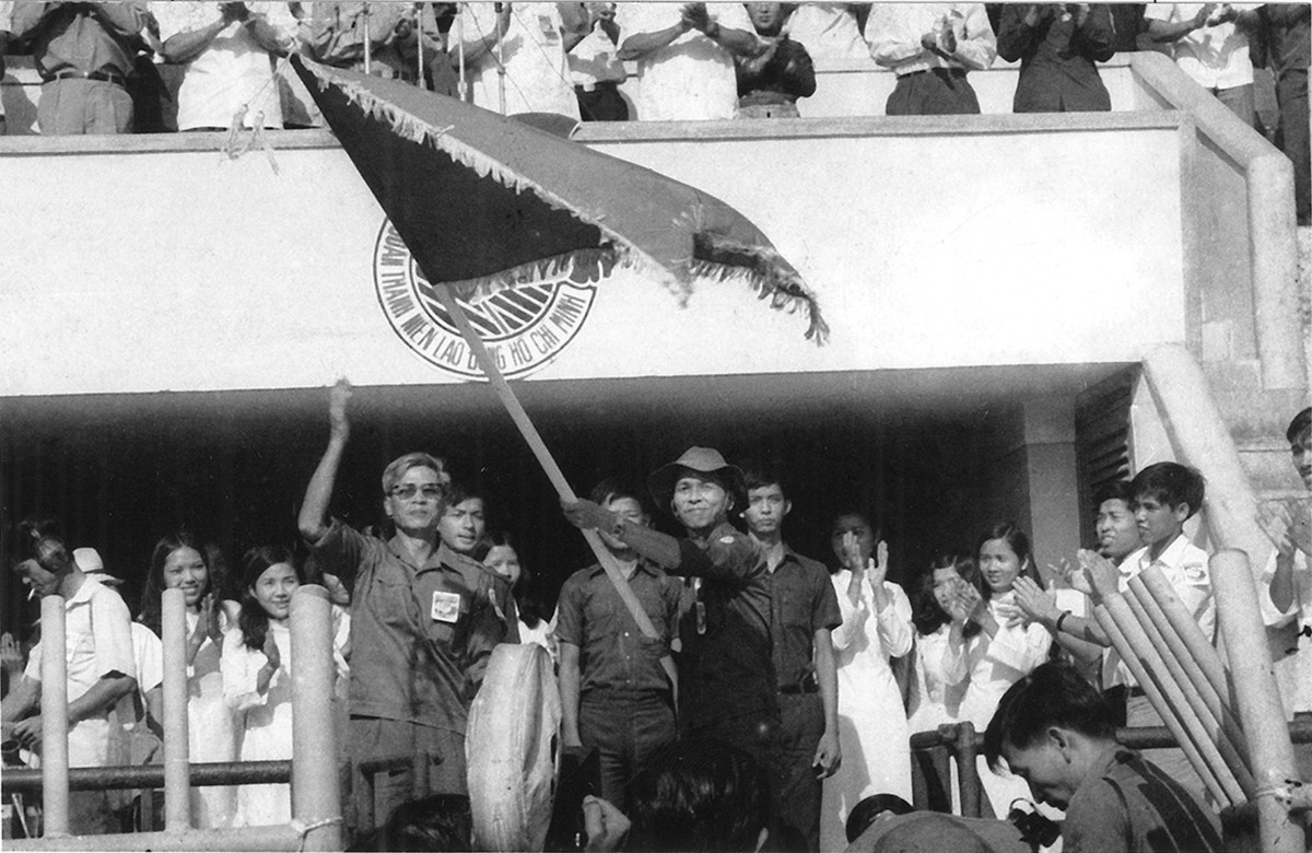  Bí thư Thành ủy TP HCM Võ Văn Kiệt trao cờ cho Bí thư Thành đoàn TP HCM Phạm Chánh Trực ra quân Thanh niên xung phong năm 1976. Ảnh: Tư liệu Thành đoàn TP HCM