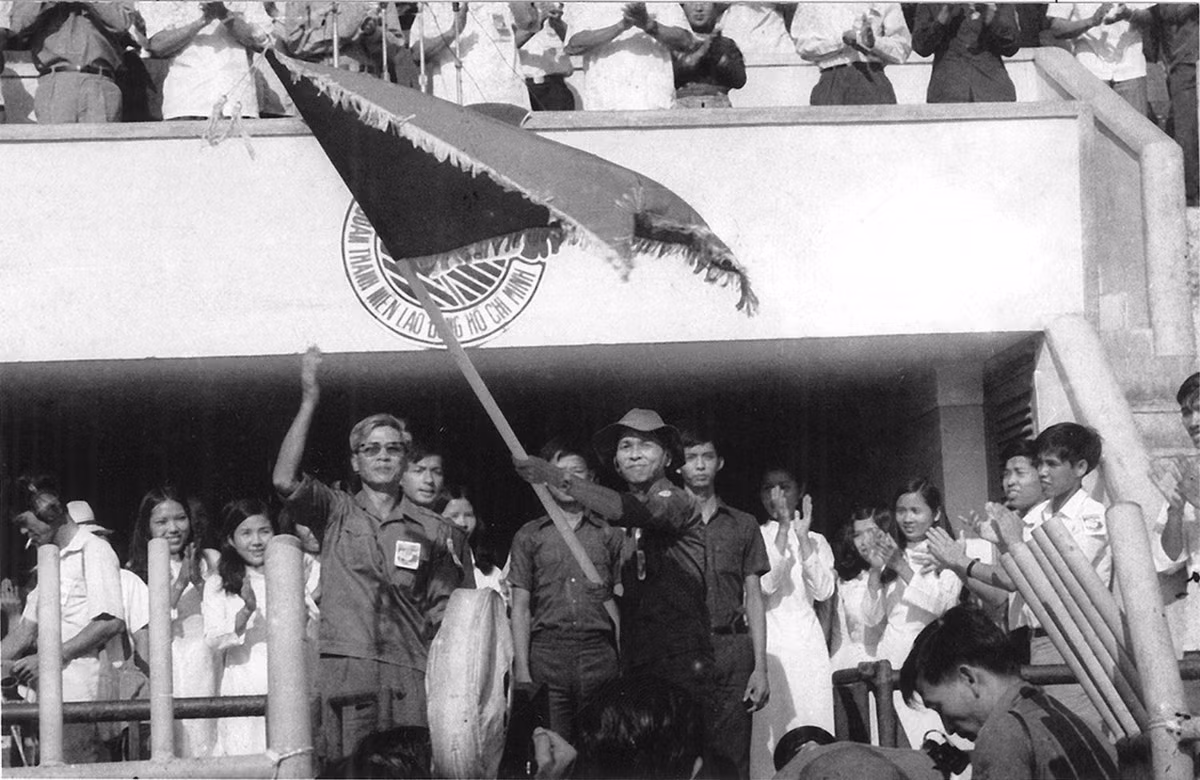  Bí thư Thành ủy TP HCM Võ Văn Kiệt trao cờ cho Bí thư Thành đoàn TP HCM Phạm Chánh Trực ra quân Thanh niên xung phong năm 1976. Ảnh: Tư liệu Thành đoàn TP HCM