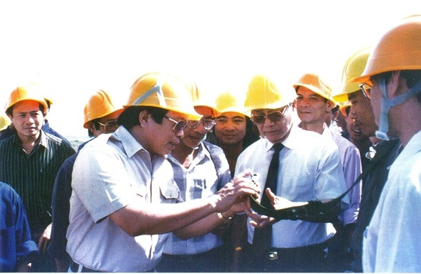 Ông Trần Viết Ngãi - Phó Trưởng Ban chỉ đạo công trình đường dây 500 KV, Tổng Giám đốc Công ty Xây lắp điện 3 - giới thiệu về thiết bị an toàn lao động với Thủ tướng Võ Văn Kiệt trên công trường thi công. Ảnh: Tư liệu