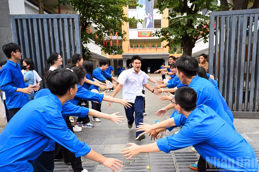 Các tình nguyện viên nhiệt tình cổ vũ khi có thí sinh bước ra từ điểm thi.