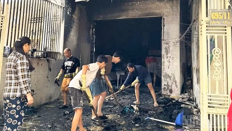 Các lực lượng cùng người dân hỗ trợ gia đình dọn dẹp khắc phục hậu quả sau vụ hỏa hoạn.