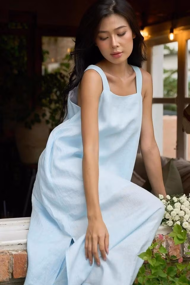 Đầm linen màu xanh thiên thanh cuốn hút bởi nét đẹp tự nhiên, dịu dàng nhưng đầy đủ sự thanh lịch và tinh tế. Thiết kế này có thể kết hợp thêm áo blazer để mặc đi làm công sở, dự các buổi họp và sau đó trở thành trang phục dạo phố, hẹn hò sau giờ làm