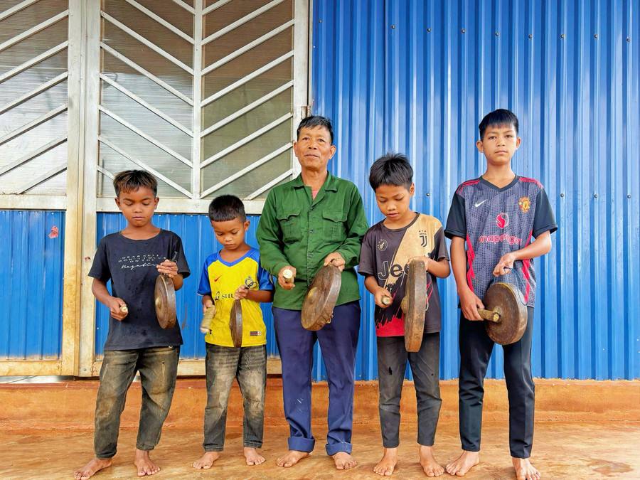 Ông Mlang cùng các học trò nhỏ trong đội chiêng làng Kol. Ảnh: Đồng Lai ong-mlang-cung-cac-hoc-tro-nho-trong-doi-chieng-lang-kol-anh-dong-lai.jpg