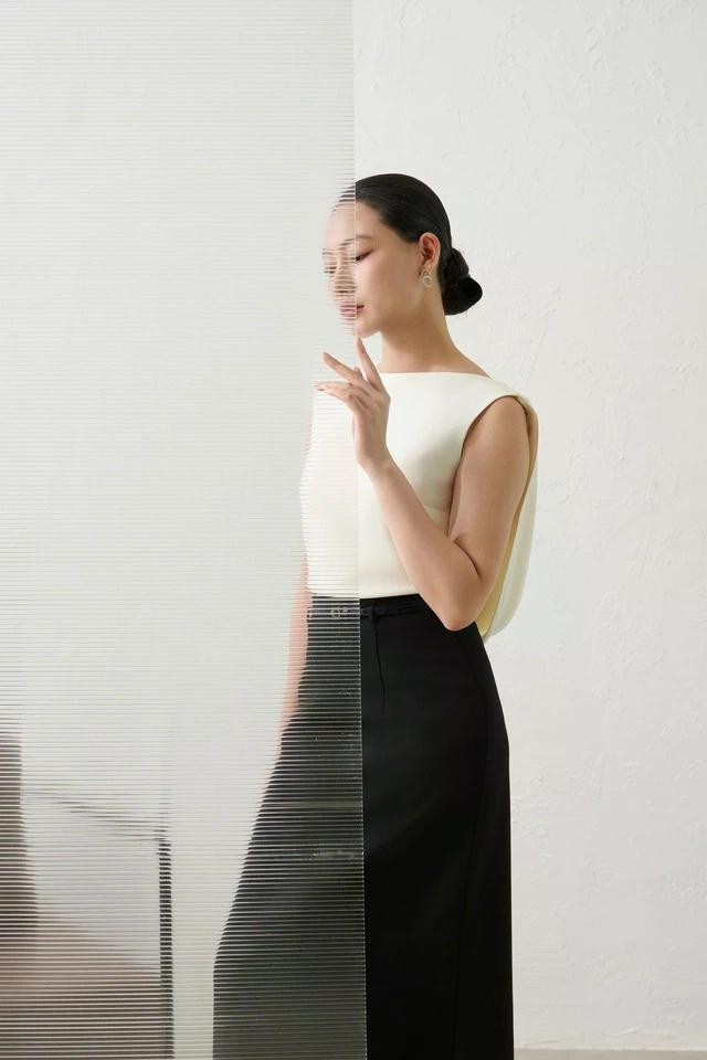 Áo cổ thuyền vải lụa với phần thân sau cách điệu phối chân váy dáng dài vừa tôn dáng khéo léo vừa phù hợp với phong cách business core