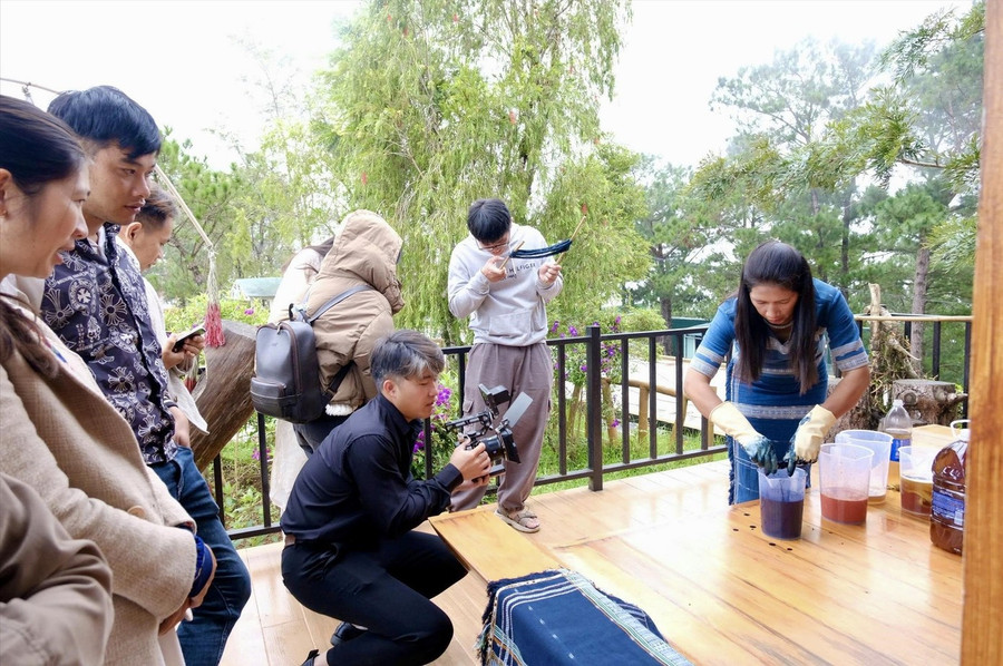 Du khách trải nghiệm nhuộm sợi cùng chị Bon Niêng K’Gút (bìa phải). Du khách trải nghiệm nhuộm sợi cùng chị Bon Niêng K’Gút (bìa phải).