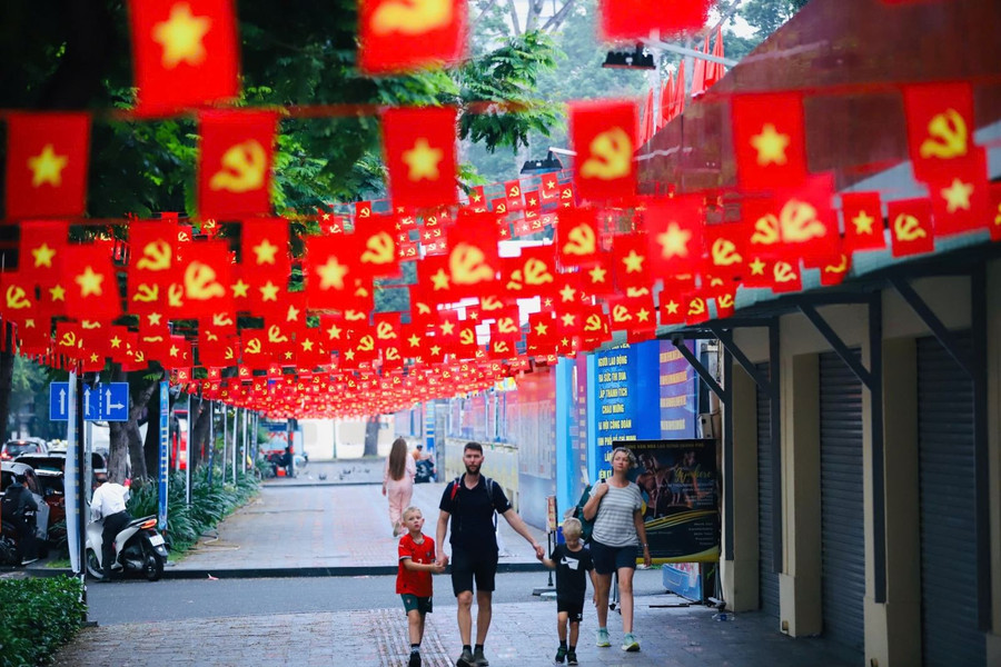 Du khách nước ngoài thích thú với những khu vực trang trí cờ đỏ sao vàng tại TP Hồ Chí Minh.