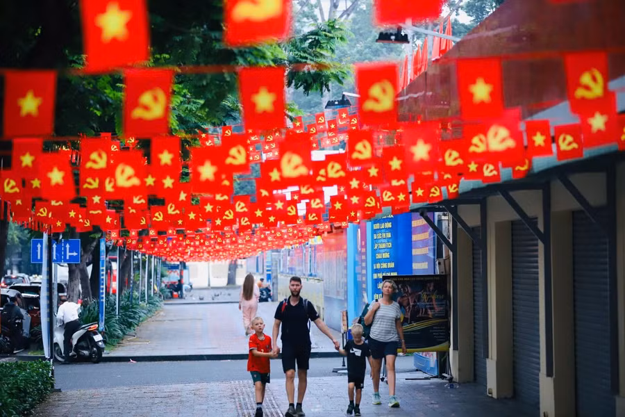 Du khách nước ngoài thích thú với những khu vực trang trí cờ đỏ sao vàng tại TP Hồ Chí Minh.