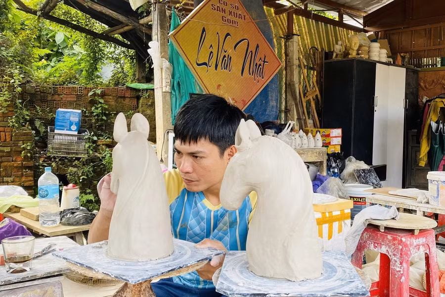 Thợ gốm trẻ Lê Văn Nhật chế tác sản phẩm bình hoa hình con ngựa được khách đặt hàng Ảnh: Hoài Văn