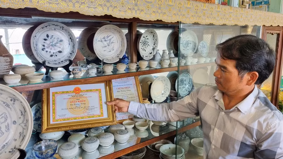 Cổ vật chen lẫn vỏ ốc biển trưng trong tủ của gia đình một ngư dân ở thôn Châu Thuận Biển. Ảnh: Nguyễn Ngọc