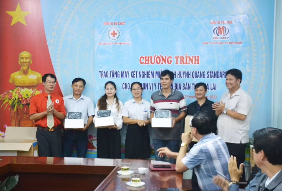 Ông Dương Đình Diện-Chủ tịch Hội CTĐ tỉnh (bên trái) và bà Phạm Thị Như Quỳnh-đại diện Công ty cổ phần Y tế AMV GROUP(đứng giữa) trao tặng máy xét nghiệm miễn dịch huỳnh quang Standar TM F200 cho đại diện các đơn vị y tế trên địa bàn tỉnh Gia Lai. Ảnh: Hoàng Cư