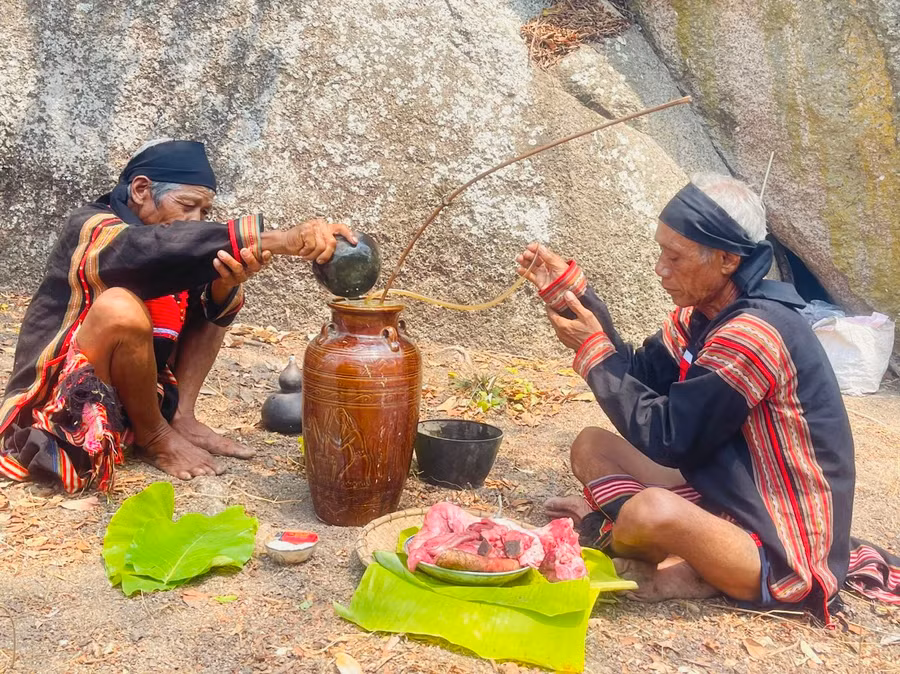 Ông Siu Phơ (bìa phải) thực hiện nghi lễ cúng với sự hỗ trợ của ông Rah Lan Hieo. Ảnh: Vũ Chi
